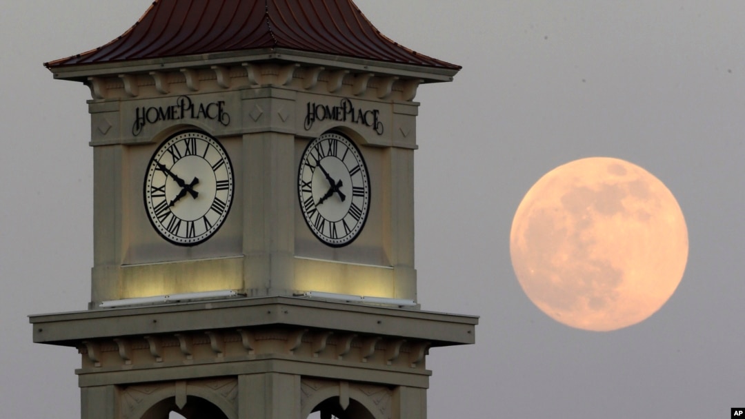 ARCHIVO: La Luna vista detrás de la torre con reloj de Home Place, el 22 de junio de 2013, en Prattville, Alabama. 