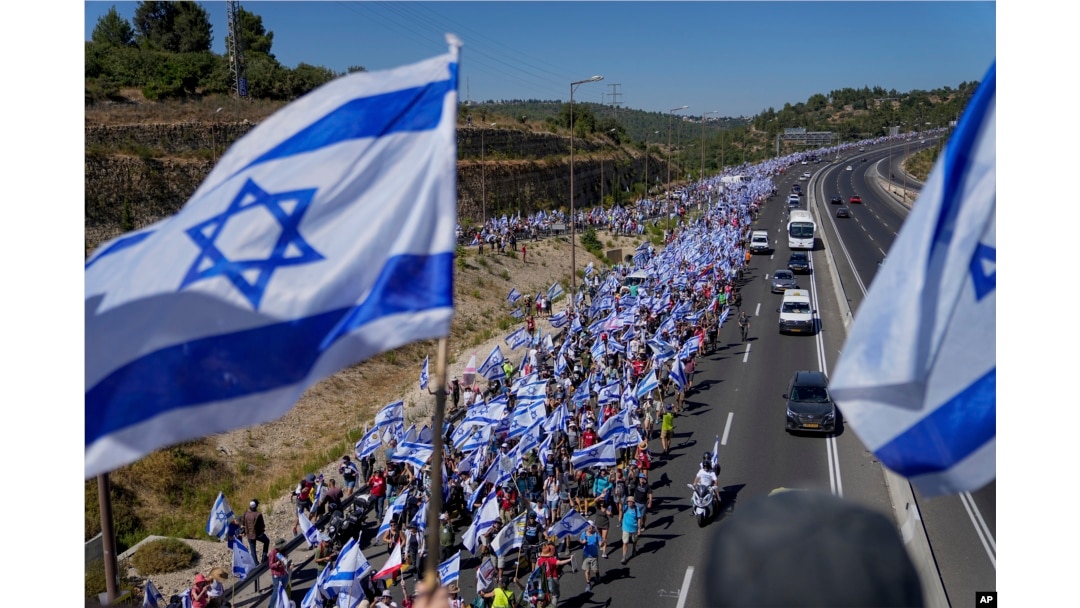 Miles de israelíes marchan por una carretera hacia Jerusalén en protesta por los planes del gobierno de Netanyahu de reformar el sistema judicial, cerca de Abu Gosh, Israel, el 22 de julio de 2023.
