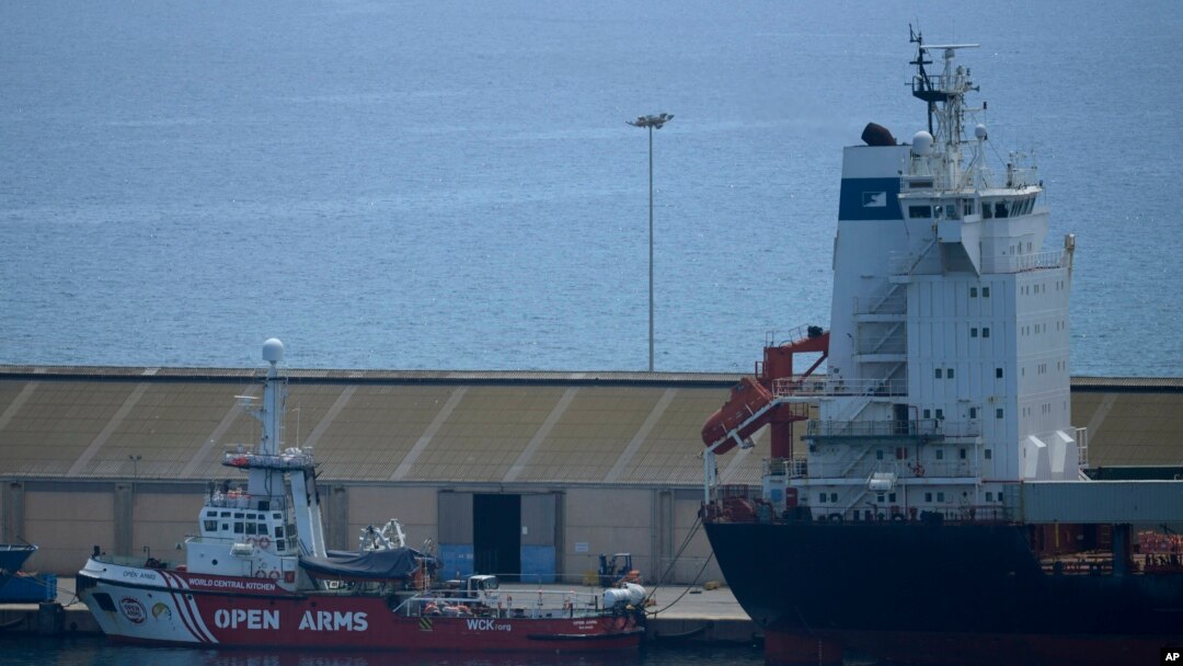 Vista del barco Open Arms y del portacontenedores Sagamore, derecha, atracados en el puerto de Larnaca, Chipre, el miércoles 8 de mayo de 2024, donde se cargan alimentos con destino a Gaza para su eventual entrega. (Foto AP/Petros Karadjias)