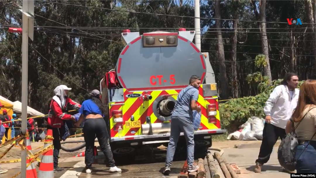 Miembros de diferentes entidades gubernamentales y de ONGs, entregan botellas de agua a la comunidad afectada y a las personas que han aportado en apagar los incendios.