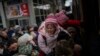 Las personas que sostienen a sus hijos luchan por subir a un tren a Lviv en la estación de Kiev, Ucrania, el lunes 7 de marzo de 2022. [Foto AP/Emilio Morenatti]