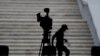 ARCHIVO - Un hombre cuenta los pasos entre sillas mientras se prepara para un evento de prensa con distanciamiento social con el presidente mexicano Andrés Manuel López Obrador, en la comuna de Coyoacán de la Ciudad de México, en abril de 2020.