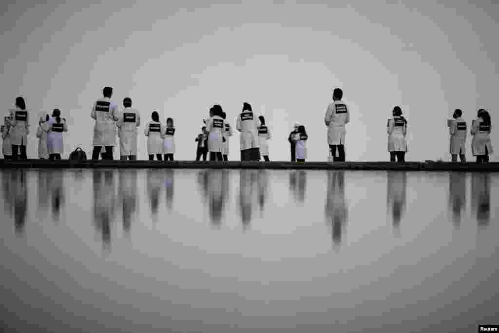 Nurses wearing protective face masks participate in a protest with signs bearing the names of healthcare professionals who died from the coronavirus disease (COVID-19) in Brasilia, Brazil, May 12, 2020.