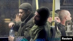 Soldados ucranianos que se han rendido a las tropas rusas después de semanas escondidos en la acería de Azovstal llegan a un centro de detención en el asentamiento de Olenivka en la región de Donetsk, Ucrania, el 17 de mayo de 2022.