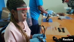 FILE - Workers prepare face shields from recycled plastics at the Zaidi Recyclers workshop in Dar es Salaam, Tanzania, May 27, 2020.