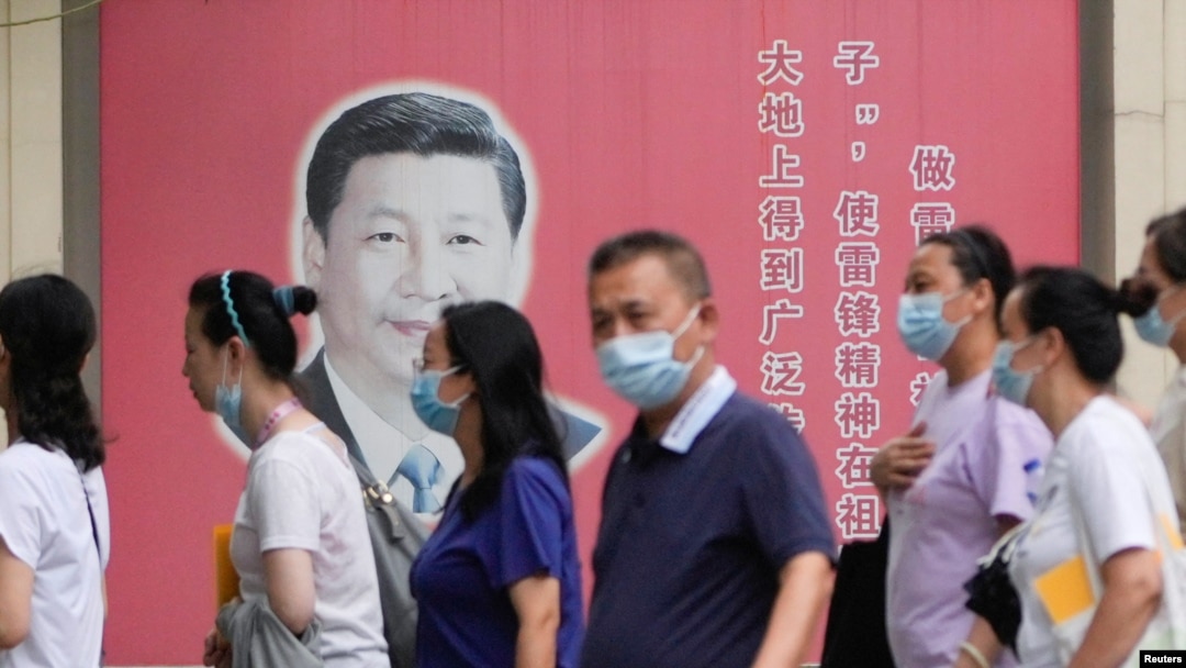 上海民众走过街头树立的一面中国领导人习近平的宣传画。（2022年8月31日）