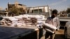 A worker holds a bag of flour in Jamila market, the wholesale market for food commodities, after a noticeable rise in the prices of flour and cooking oil, in Baghdad, Iraq, March 16, 2022.