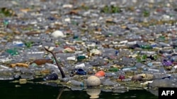 FILE - Plastic residues, glass and other materials are seen at the Cerron Grande reservoir in Potonico, El Salvador, on Sept. 9, 2022.