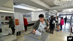 ARCHIVO - Personas de las regiones de Luhansk y Donetsk, el territorio controlado por gobiernos separatistas prorrusos, que viven en Crimea, votan durante un referéndum en Sebastopol, Crimea, el viernes 23 de septiembre de 2022.