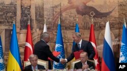 Los representantes de Ucrania y Rusia se dan la mano después de firmar un acuerdo de exportación de granos en Estambul el 22 de julio de 2022. En la primera línea se observa al secretario general de la ONU, Antonio Guterres, y el presidente turco Recep Tayyip Erdogan. 