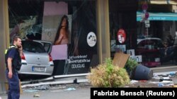 Policajac pored izloga u koji je uleteo automobil u Berlinu
