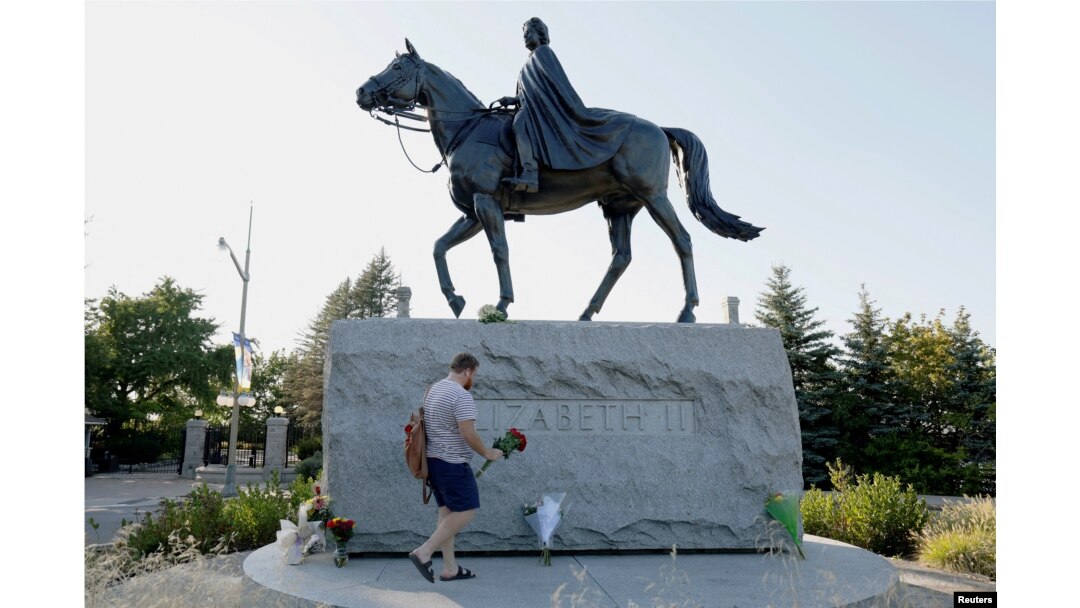 FILE PHOTO: Breton Cousins brings flowers to a statue of Queen Elizabeth II near Rideau Hall, after Queen Elizabeth, Britain's longest-reigning monarch and the nation's figurehead for seven decades, died aged 96, in Ottawa, Ontario, Canada, September 8,