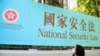 香港一名妇女走过街头的国安法宣传牌（美联社2020年6月30日）