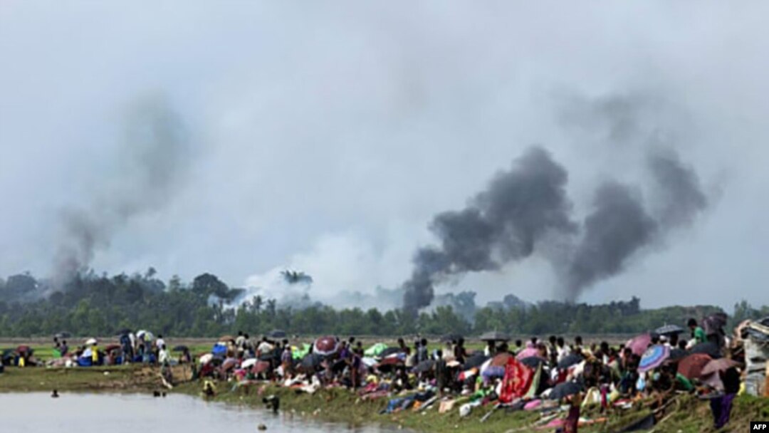 ရခိုင်ပြည်နယ်အတွင်းရှိ ကျေးရွာအချို့ မီးရှို့ဖျက်ဆီးခံရသည်ကို ကြည့်ရှုနေသည့် ဒေသခံများ။ (ဓာတ်ပုံ - KM Asad/AFP/Getty Images)