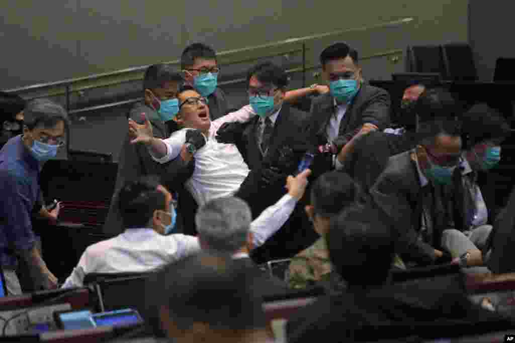 Pan-democratic legislator Lam Cheuk-ting is taken away by security during a Legislative Council's House Committee meeting in Hong Kong.