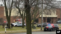 Emergency vehicles are parked outside the Abundant Life Christian School in Madison, Wis., where a shooting occurred, Dec. 16, 2024. A teacher, a student and the shooter were killed, police said.