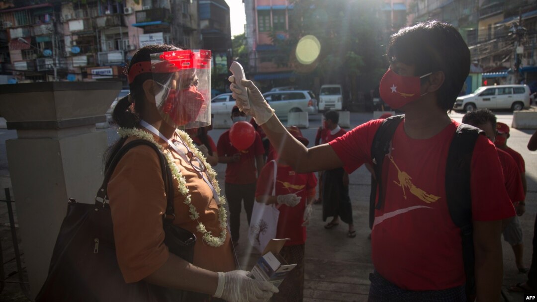 ရွေးကောက်ပွဲ မဲဆွယ်စည်းရုံးရေးစတင်တဲ့နေ့မှာ အမျိုးသားဒီမိုကရေစီအဖွဲ့ချုပ် (NLD) ပါတီကို ထောက်ခံသူတချို့နဲ့ တက်ကြွလှုပ်ရှားသူတဦးအား ကိုယ်အပူချိန်တိုင်းပေးနေသူတဦးကို ရန်ကုန်မြို့မှာတွေ့ရ။ (စက်တင်ဘာ ၈၊ ၂၀၂၀)