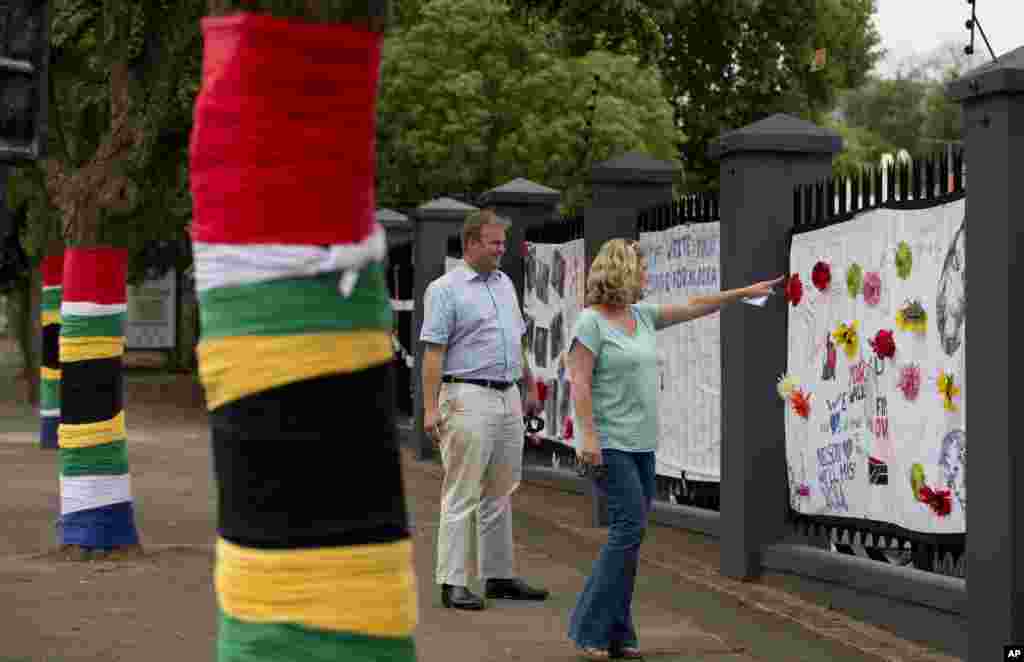 Deixam-se mensagens para Nelson Mandela num passeio ornamentado com bandeiras sul-africanas nas árvores, em Rosebank, distrito muito movimentado em Joanesburgo, Dez. 9, 2013. 