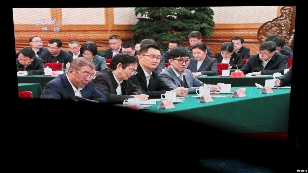 北京某購物中心的巨型電子螢幕播放的新聞畫面顯示，數位知名中國營企業家在北京舉行的座談會上聽取中國領導人習近平講話的場景。 （2025年2月17日）