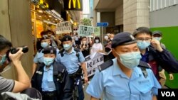 香港支聯會及社民連4名成員4月15日首個國家安全教育日遊行示威，被大批軍裝警員包圍 （美國之音湯惠芸）