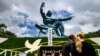 Watu wamesimama katika uwanja wenye sanamu la amani, Peace Statue kuadhimisha miaka 75 tangu Nagasaki ilipopigwa bomu la atomic Leo Agosti 9, 2020.