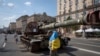 Un hombre con una bandera ucraniana visita una avenida donde se exhiben vehículos militares rusos destruidos antes del Día de la Independencia en Kiev, Ucrania, el lunes 21 de agosto de 2023. [Foto: Archivo/AP]