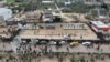 Palestinos se agrupan antes de la entrega a la Cruz Roja de tres rehenes israelíes por parte de Hamás como parte del acuerdo de alto el fuego de Gaza con Israel en Deir Al-Balah, el sábado 8 de febrero de 2025. 