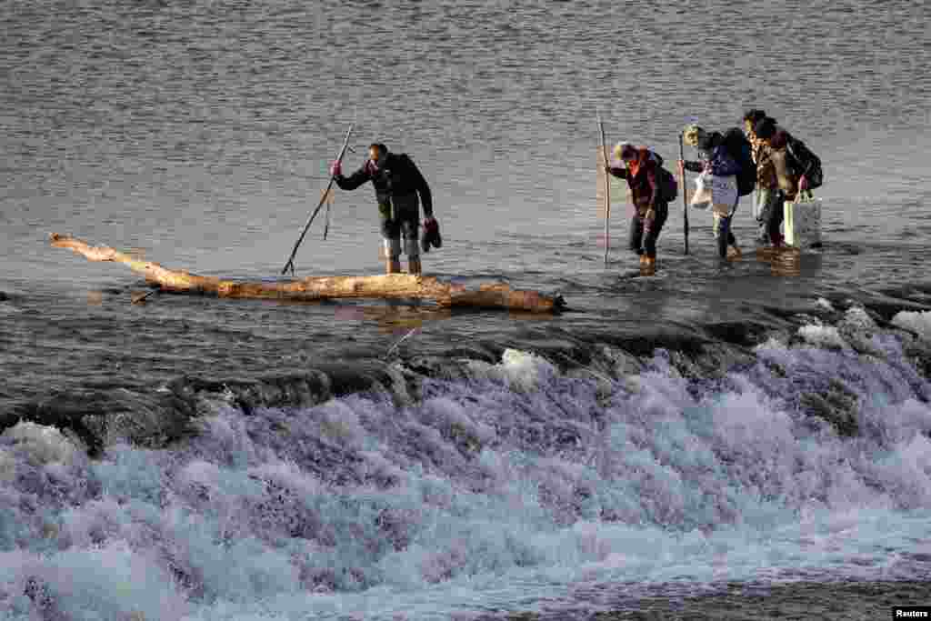 Migrants cross Meric river toward the Turkey's Pazarkule border crossing with Greece's Kastanies, near Edirne, Turkey.
