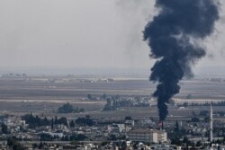 FILE - Fire and smoke rise from the Syrian town of Ras al-Ayn, Oct. 18, 2019.