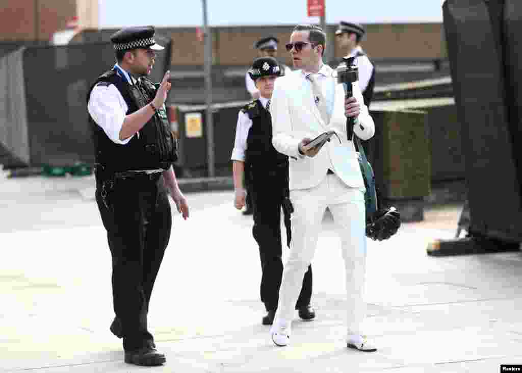 Police officers speak with a man who was preaching outside St Thomas' hospital in London.