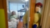 Registered nurse Rachel Chamberlin steps out of an isolation room where where Fred Rutherford recovers from COVID-19 at Dartmouth-Hitchcock Medical Center, in Lebanon, NH, Jan. 3, 2022.