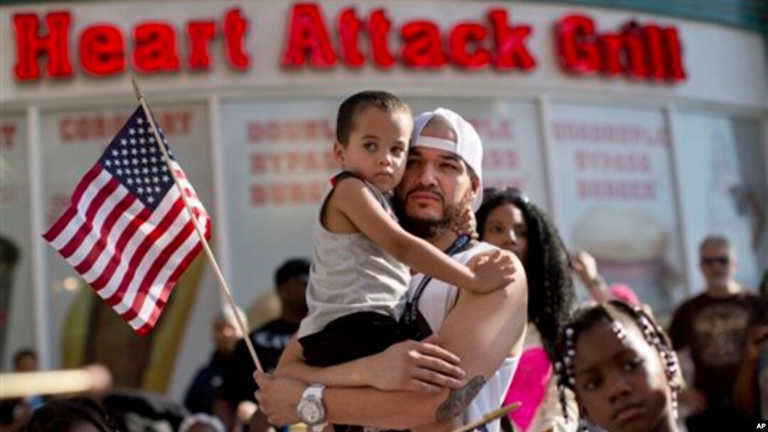 Durante las manifestaciones en Las Vegas, Ulysses Diaz sostiene a su hijo, Armani Hinton, mientras escucha los discursos sobre el veredicto del caso Zimmerman.
