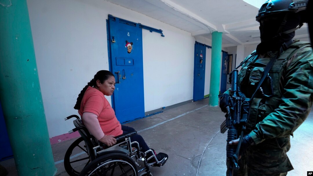 Una mujer presa observa a un soldado que vigila en la cárcel de Cotopaxi durante un recorrido para la prensa organizado por el ejército, el jueves 22 de febrero de 2024, en Latacunga, Ecuador. 