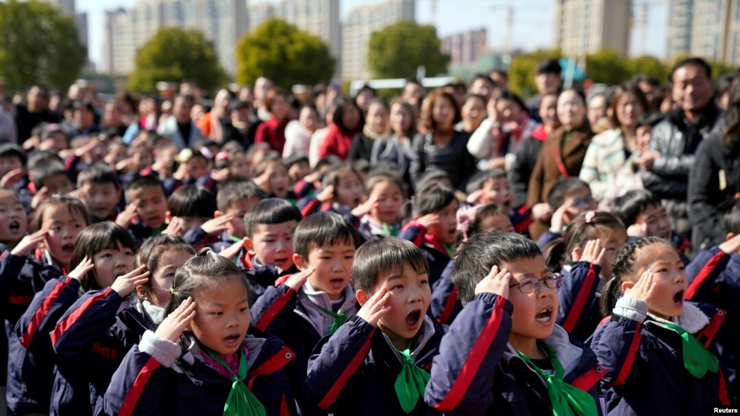 資料照：中國上海一所小學的學生們在新學期第一天舉行的升旗儀式上敬禮。 (2018年2月23日)