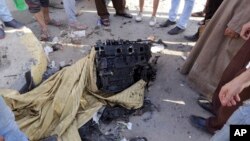 Egipcios se reunieron para observar un motor que se cree era del coche bomba usado en El Cairo, el jueves, 20 de agosto de 2015.
