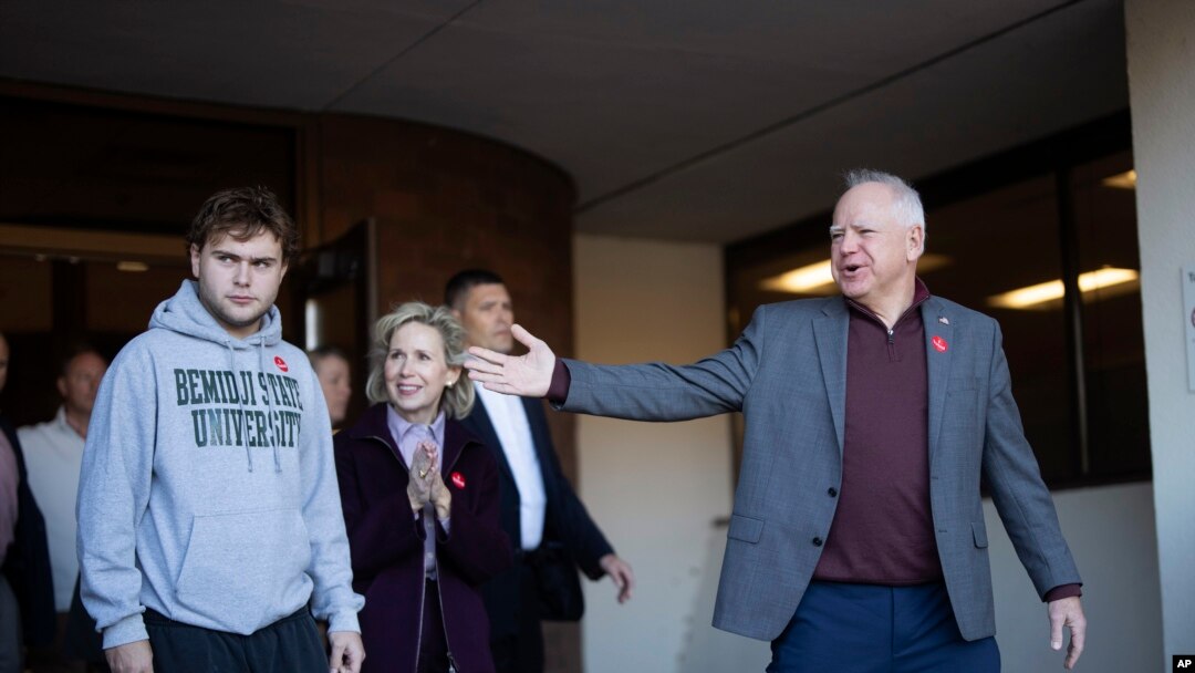 El candidato demócrata a la vicepresidencia, el gobernador de Minnesota Tim Walz, anuncia que su hijo, Gus Walz, es un votante por primera vez al salir de la oficina electoral del condado de Ramsey en St. Paul, Minnesota, el miércoles 23 de octubre de 2024.