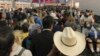 En esta imagen proporcionada por Austin Boschen, gente esperando a pasar la aduana en el Aeropuerto Internacional de Dallas Fort Worth en Grapevine, Texas, el sábado 14 de marzo de 2020. Saturday, March 14, 2020. 