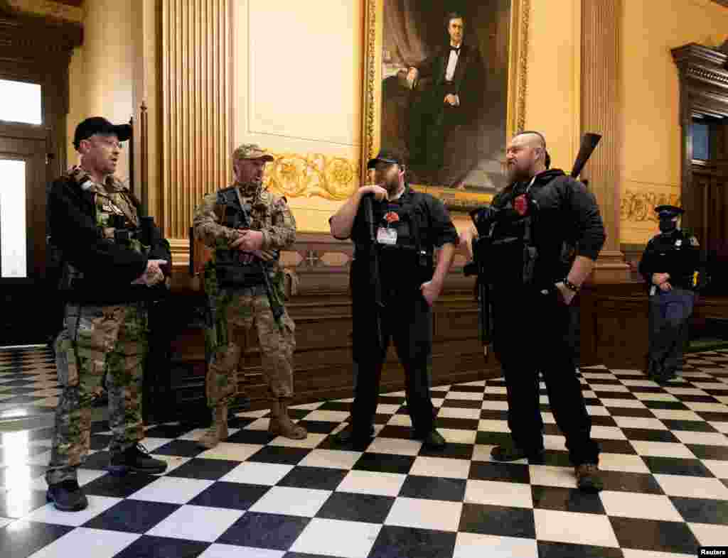 Members of a militia group stand near the doors to the chamber in the capitol building before the vote on the extension of Governor Gretchen Whitmer's emergency declaration/stay-at-home order due to the coronavirus disease (COVID-19) outbreak, in Lansing, Michigan.