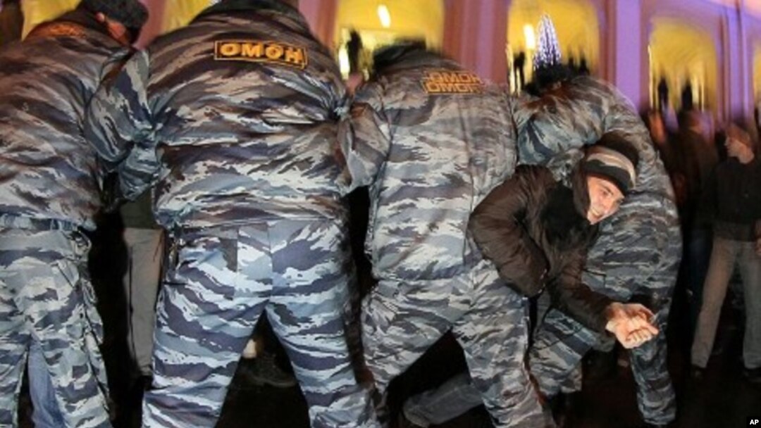 一名抗議者星期一在聖彼得堡掙扎逃脫警察的捉捕