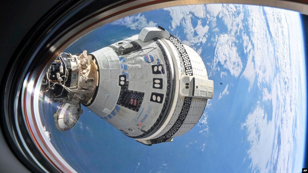 En esta imagen, de la NASA, se muestra la cápsula Starliner de Boeing, acoplada al puerto delantero del módulo Harmony, el 3 de julio de 2024, vista desde una ventana de la nave Dragon Endeavour de SpaceX, acoplada al puerto adyacente.