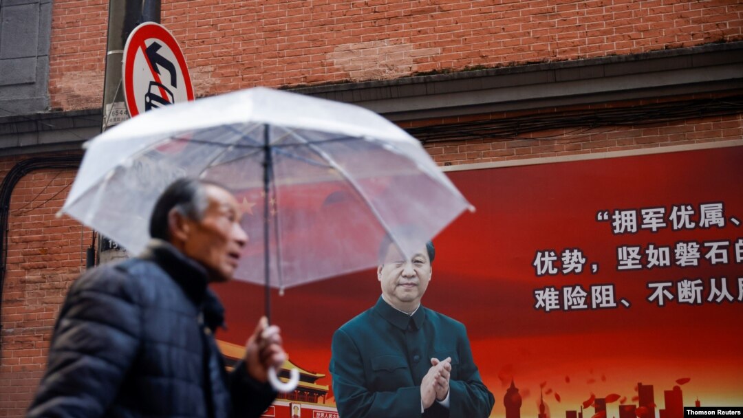 召開前夕，一名男子在上海街頭一幅有習近平像的宣傳板前走過。