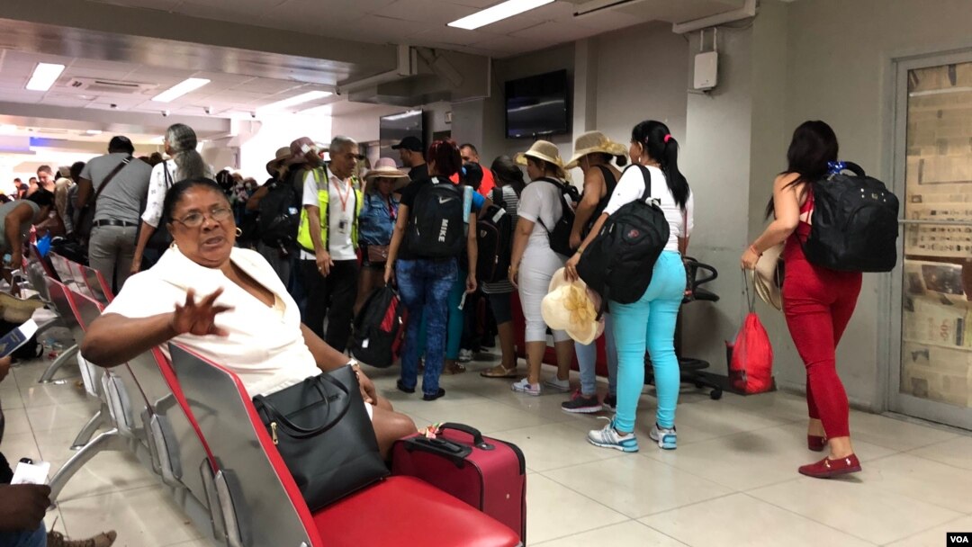 Turistas cubanos hacen cola para abordar su vuelo en el aeropuerto Toussaint Louverture en Puerto Príncipe, Haití. (S. Lemaire / VOA)