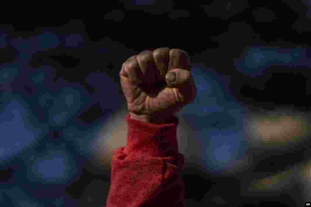 A protester clenches his fist as he sings the worker&#39;s hymn &quot;The Internationale&quot; during a half-day strike to protest government proposed reforms titled La Ley de Urgente, or The Urgent Law, in Montevideo, Uruguay.