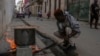 ARCHIVO - Un hombre cocina una sopa en un fuego en la acera, durante un apagón en La Habana, Cuba, el 4 de diciembre de 2024. 