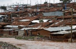 A man watches a stream from his home in Nairobi's Kibera slum, Kenya, Dec. 3, 2019.