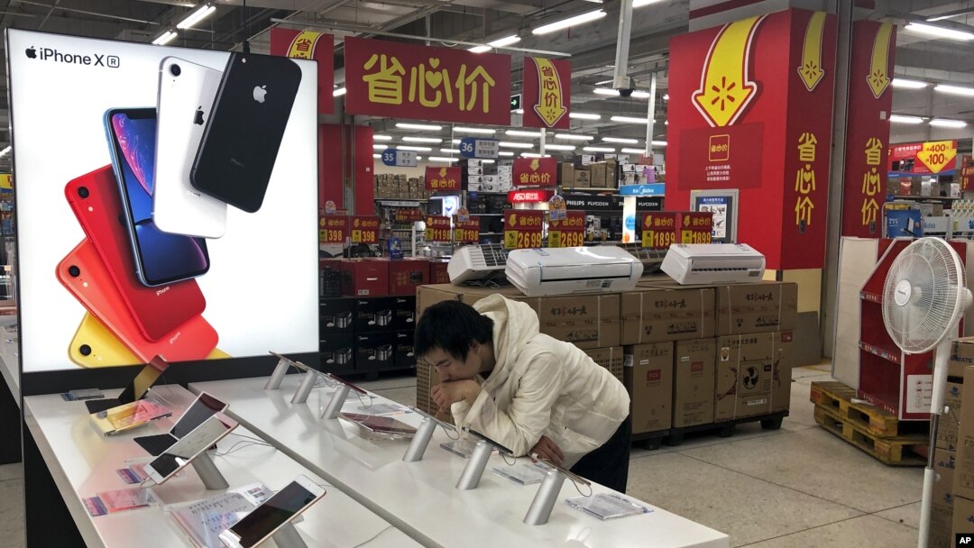 A man browses an iPhone unit on display at a market in Beijing, Thursday, May 9, 2019.