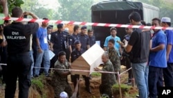 Autoridades dan sepultura a 21 víctimas del tráfico de personas, que se cree eran refugiados musulmanes rohingya, cuyos cuerpos fueron encontrados en Kedah, Malasia.