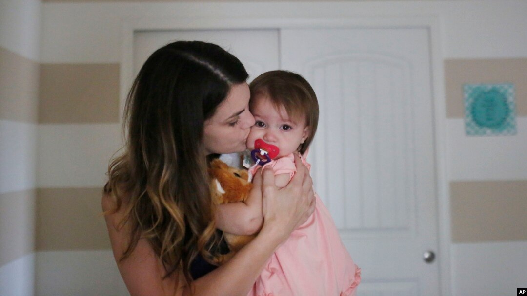 ARCHIVO- Lane Weichman, (30) de Springville, Alabama, besa a su hija Callie (1) antes de ponerla a dormir el fin de semana del Día de las Madres. Mayo 7 de 2016