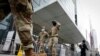 Militares estadounidenses enmascarados con tapabocas en la entrada del centro Javits de Nueva York, que ha sido convertido temporalmente en un hospital debido a la pandemia.