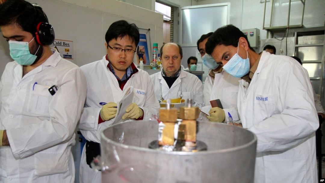 ARCHIVO: Inspectores de la Organización Internacional de Energía Atómica (OIEA) y técnicos iraníes se preparan para cortar conexiones en el sitio nuclear de Natanz en Irán el 20 de junio de 2014.